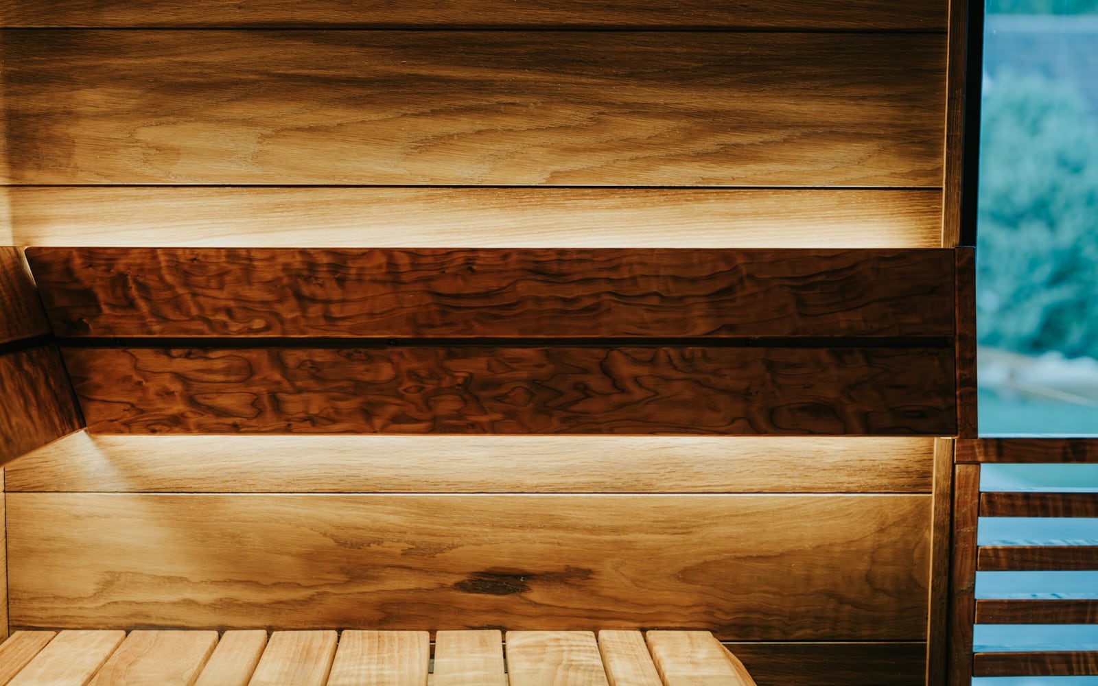 The Finnish sauna interior in warm timber with a window onto the treeline