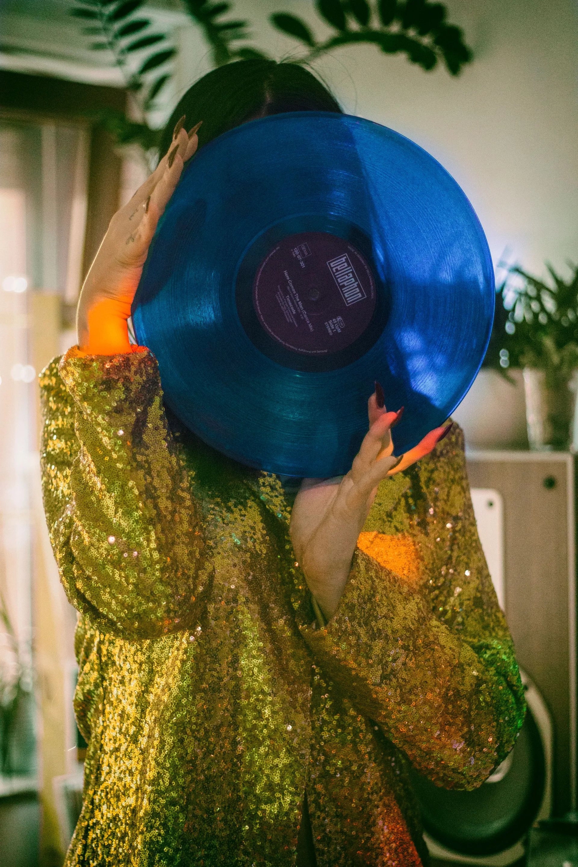A record shop customer holding a coloured vinyl record up to the light
