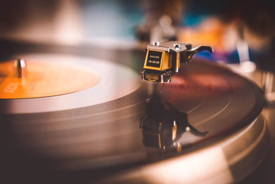 Close-up of a turntable cartridge on a warm-toned vinyl record